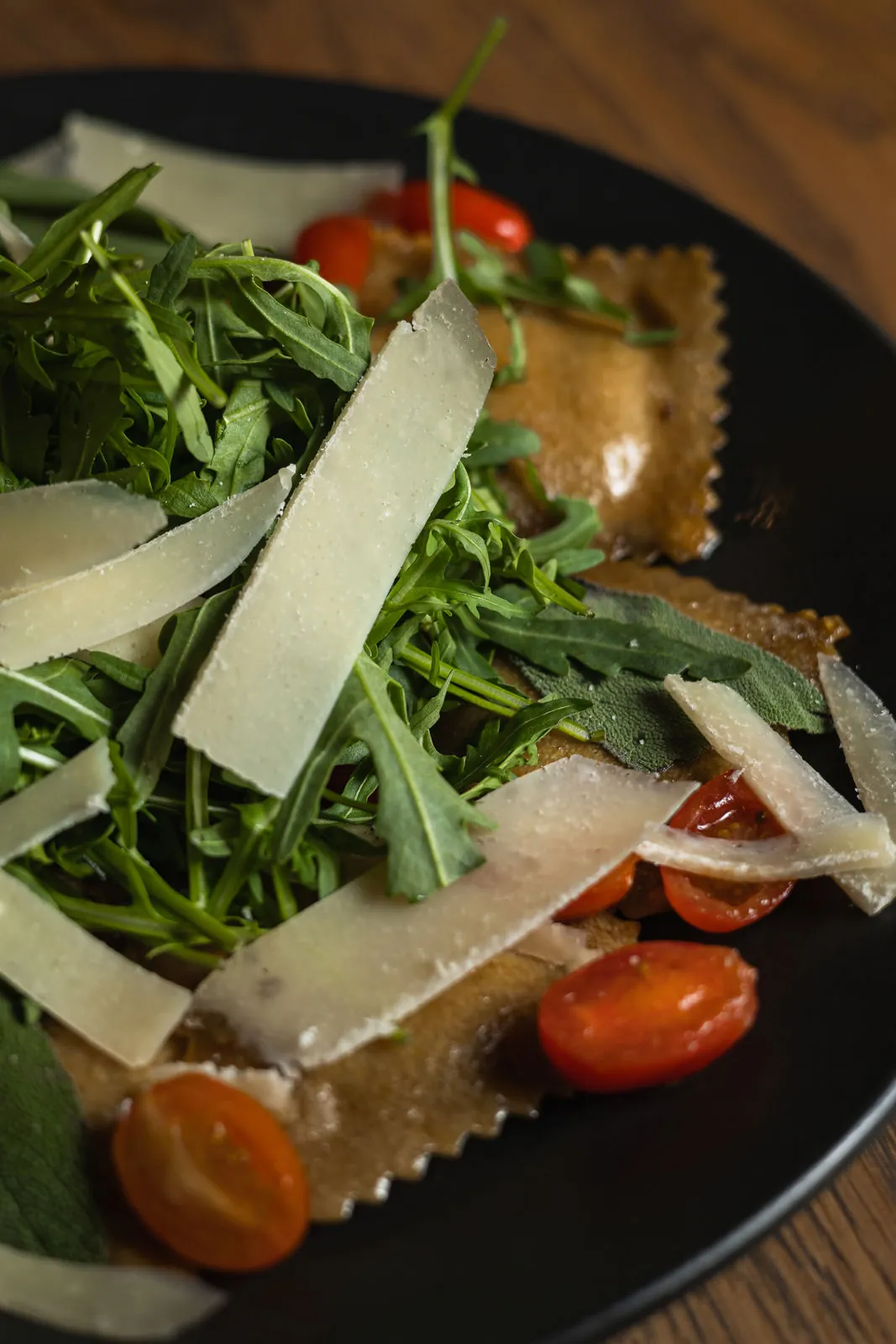 Grünes und Käse auf einem dunklen Teller